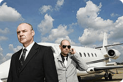 Deux agents de protection en complet foncé devant un jet privé
