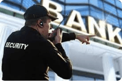 Un gardien avec radio bidirectionnelle coordonnant une intervention devant une banque